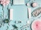 Beauty concept with facial cosmetic products, shopping bag and twigs with cherry blossom on pastel blue desktop