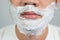 Beauty concepts for health and skin care an Asian guy with a mustache with a beard with a bubble on his face, preparing to shave