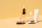 Beauty and cosmetic concept with serum bottle, cream tube on natural pedestal