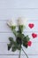 Beauty crystal white rose and red satin hearts shape on wooden floor. Valentine's day background concept