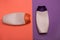 Beauty, decorative cosmetics bottles. Peach and purple colors background, flat lay, top view, minimalistic pop-art style