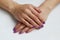 beauty delicate violet manicure with gel varnish on a white wall background