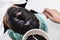 Beauty doctor apply skin alginate seaweed black mask to male patient face