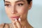 Beauty Face. Beautiful Woman Touching Lips With Lip Balm On