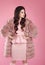 Beauty fashion elegant woman in fur coat over pink. Fashionable