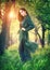 Beauty fashion model girl posing over blooming trees, enjoying nature in spring apple orchard