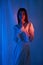 Beauty fashion woman in light white dress in studio. Freedom concert in neon color light. Fashion style light dress on body woman