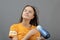 Beauty and fashion. A young Caucasian woman dries her hair with a hairdryer on a gray background