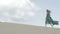 Beauty Girl in green dress running on sand dune