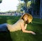 Beauty girl in hat at golf field at sunset laying on grass. lifestyle people concept