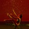 Beauty and grace. One young beautiful ballerina dancing under the rain over red background in neon light.