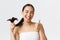 Beauty, hair loss products, shampoo and hair care concept. Close-up of satisfied, happy asian girl in bath towel showing