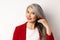 Beauty and haircare concept. Close up of elegant asian senior woman showing shiny and healthy grey hair, smiling and