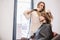 Beauty, hairstyle concept, happy young woman and hairdresser with hair iron making hairdo at hair salon. Woman Having