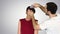 Beauty, hairstyle and people concept - young woman with hairdresser with hair spray on gradient background.
