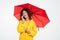 Beauty happy african woman in raincoat hiding under umbrella