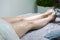 Beauty Ideas. Hands of Professional Beautician With Soothing Cream on Female`s Legs After Wax Depilation In Spa