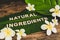 Beauty industry and ethical vegan products, Natural Ingredients message on tropical banana leaf with monoi flowers