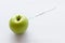 Beauty injection concept. Syringe and green apple on white background copy space