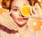 Beauty joyful teenage girl takes juicy oranges. Teen model girl with freckles, funny red hairstyle, yellow makeup and nails