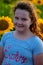 Beauty joyful young girl with sunflower enjoying nature and laughing on summer sunflower field. Sunflare, sunbeams, glow