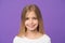 Beauty look and skincare. Little girl smile on violet background. Child with fresh skin on cute face. Beauty kid with