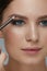 Beauty makeup. Woman shaping eyebrow with brow pencil closeup