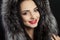 Beauty is a model girl in a black fur coat. Beautiful winter luxury woman. Photographed photo. Professional makeup. Red lips. Youn