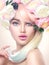 Beauty model girl with colorful flowers wreath and colorful hair. Flowers hairstyle