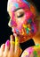 Beauty model girl with colorful paint on her face. Portrait of beautiful woman with flowing liquid paint