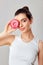 Beauty model holds a pink donut. Laugh. Diet. Funny. Brunette woman  tastes a donut.