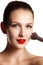 Beauty model with makeup Brush. Bright make-up for brunette woma