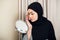 Beauty muslim woman with hijab applying makeup. Beautiful girl looking in the mirror and applying cosmetic. Girl gets