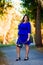Beauty plus size model in blue dress outdoors, fat woman in autumn park among yellow leaves