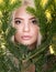 Beauty portrait of beautiful young woman in the branches of a spurce