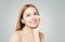 Beauty portrait of cute young woman smiling while applying some facial cream on her cheek