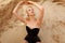 Beauty portrait of a sensual blonde model in black bodysuit, posing gorgeous in sand