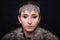 Beauty portrait of a woman with a chain mail bezel on her head and fur on her shoulders. Studio photo on a black background