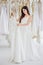 Beauty portrait of young asian bride choosing wedding dress in  wedding salon of  fashion store ,luxury