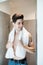 Beauty portrait of a young man in a home bathroom with a white towel around his neck, thoughtful looking at camera, interior.