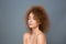 Beauty portrait of young natural woman with voluminous curly hairstyle