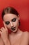 Beauty portraits of a beautiful girl with make-up in Halloween style on a red background