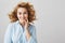 Beauty and positive emotions concept. Indoor shot of sensual emotive young woman in blue blouse with short stylish curly