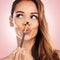 Beauty, pout and face of woman with makeup brush on pink background for salon, wellness and luxury. Cosmetology