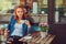 A beauty redhead girl drinks coffee, sitting near the coffee shop.