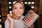 Beauty room. Cheerful nice young woman look on camera and smile. She applying eyeshadows with brush. Colorful palette in