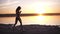 Beauty runner woman running over sunset. Young woman jogging along the sea coast. Healthy lifestyle concept. Slow motion