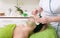 Beauty salon. Cosmetician removing facial mask from woman face.