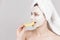 Beauty and skin care concept. young woman bites slice of lemon. girl with moisturizing facial mask