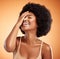 Beauty, skincare and black woman with afro hair touching face with makeup, cosmetics and laughing while happy with